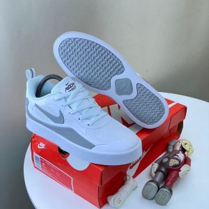 Nigerian-style sneakers in white and gray, showcasing the Air Max X and Air Max Boost designs. The Air Max X features a breathable mesh upper, a white midsole, and a gray outsole. The Air Max Boost has a white midsole, a gray outsole, and a white upper with a subtle Nike swoosh.